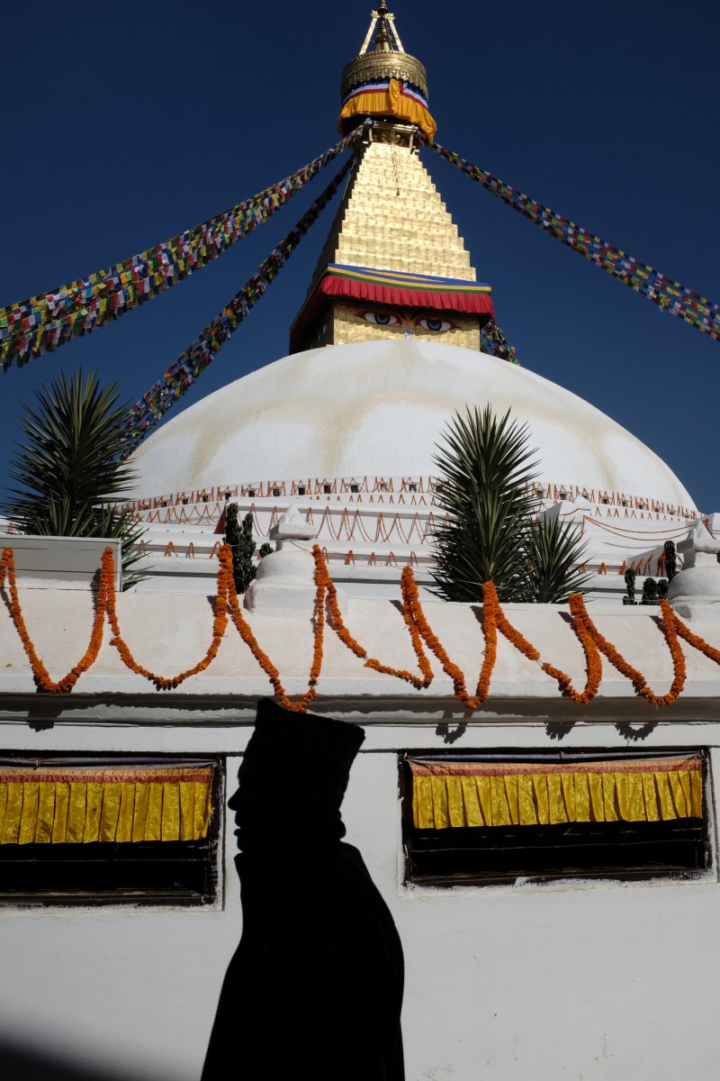 man walking in front of stupa in kathmandu