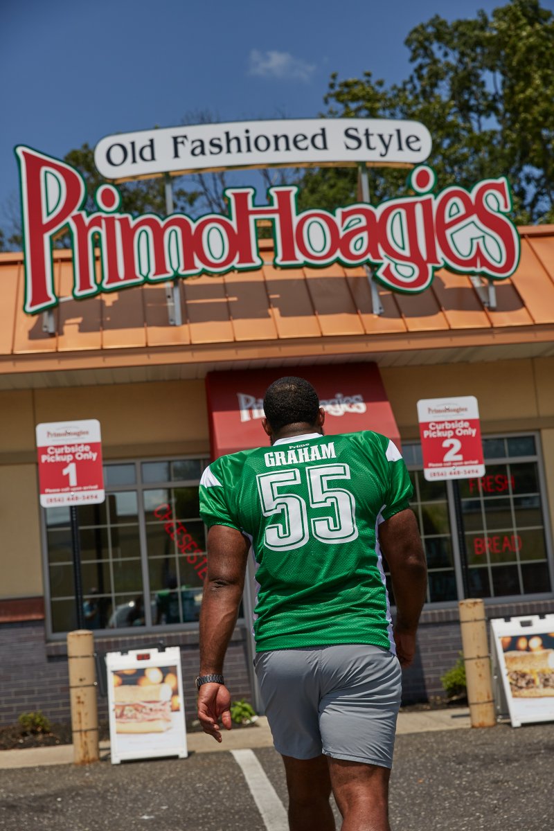Philadelphia Eagles defensive end Brandon Graham walking toward a Primo Hoagies storefront. 